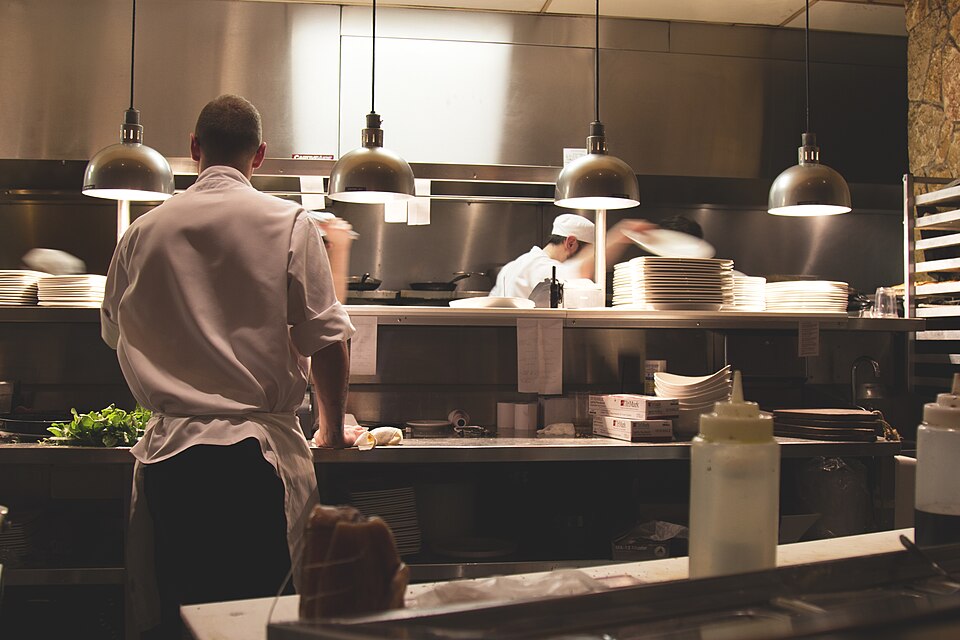 Cozinha profissional com a equipe trabalhando no serviço