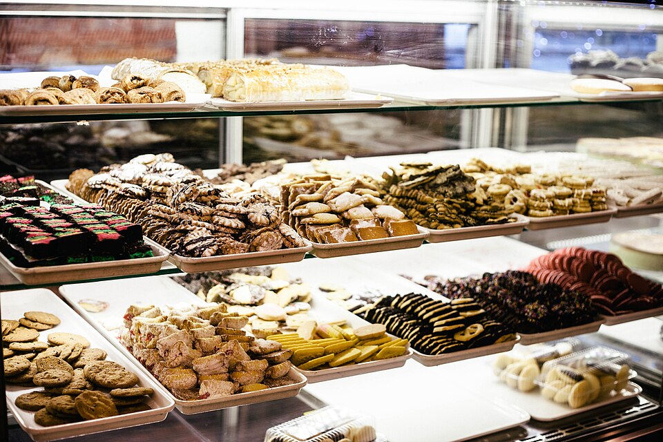 Vitrine de confeitaria com bandejas de doces e biscoitos